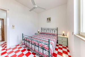 a bedroom with a bed and a red and white checkered floor at Le Carrube Vista Mare in Andrano