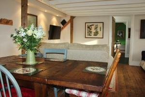 a living room with a wooden table and a couch at Bessie May Cottage in Beaulieu