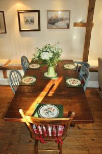 a wooden table with a vase of flowers on it at Bessie May Cottage in Beaulieu