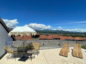 a patio with a table and chairs and an umbrella at La terrazza sul Ricetto - Appartamento Suite in Candelo