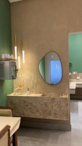 baño con bañera con espejo y TV en Hotel Grutta, en Bom Jesus da Lapa