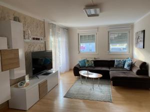 a living room with a couch and a tv at Apartment Katharina in Klagenfurt