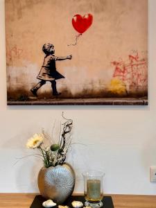 a painting of a child holding a heart balloon at Appartement Treffhour in Ellmau +12 photos
