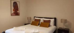 a bedroom with a bed with white sheets and orange pillows at Cozy apartment in Madeira Island in Ribeira Brava +1 photo