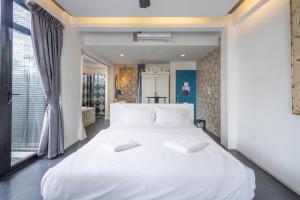 a large white bed in a room with a window at See Sea Villa Phuket SHA in Patong Beach