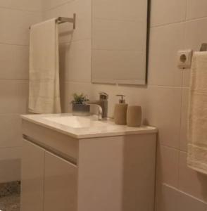 a white bathroom with a sink and a mirror at Cozy apartment in Madeira Island in Ribeira Brava
