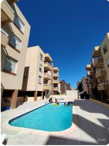 una piscina frente a unos edificios de apartamentos en 2 Quartos Praia Capão Novo - Capão da Canoa RS, en Capão da Canoa