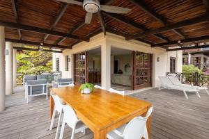 a wooden dining table and chairs on a deck at The Village at Blue Bay Golf & Beach Resort in Sint Michiel
