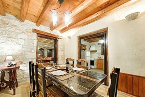 a dining room with a table and a stone wall at Villa Poseidon Residences - Poolside Zante Nests in Skinária