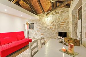 a living room with a red couch and a table at Villa Poseidon Residences - Poolside Zante Nests in Skinária