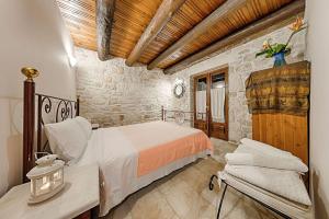 a bedroom with a bed and a chair in a room at Villa Poseidon Residences - Poolside Zante Nests in Skinária +85 photos