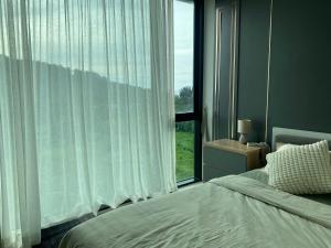 a bedroom with a bed and a large window at Patong Sea View pool view condo in Patong Beach +14 photos