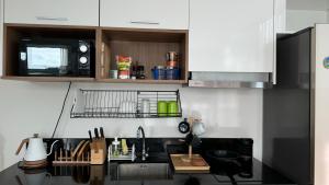 a kitchen with a sink and a microwave at Patong Sea View pool view condo in Patong Beach
