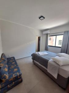 Un dormitorio con una cama grande y una ventana. en Casa de praia Brisa das Amendoeiras, en Palhoça 17 fotos más