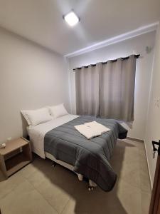Un dormitorio pequeño con una cama con ventana. en Casa de praia Brisa das Amendoeiras, en Palhoça