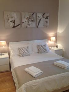 una camera da letto con un grande letto bianco con tre immagini sul muro di Casa Maron a Firenze