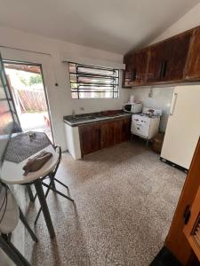 a small kitchen with a table and a refrigerator at CaSaBELLa in La Floresta