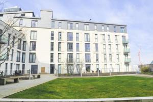 a white building with a lawn in front of it at City Centre Flat within the Hayes Complex in Cardiff