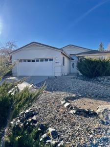 una casa blanca con una entrada de grava delante de ella en Grand Residence - Spacious Retreat - 3 bed, 2 bath, en Prescott
