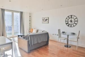 a white living room with a bed and a table at City Centre Flat within the Hayes Complex in Cardiff