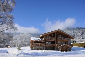 a large log cabin with snow on the ground at Chalet Le Prariand - Megève in Megève +9 photos