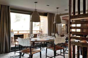 a dining room with a table and chairs with wine glasses at Chalet Le Prariand - Megève in Megève