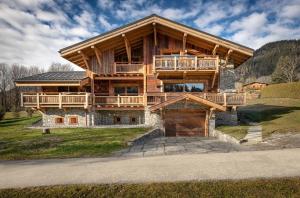 a large wooden house with a large deck at Chalet Le Prariand - Megève in Megève