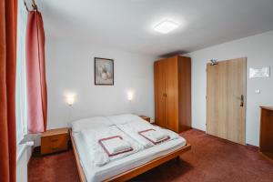 a bedroom with a white bed and a wooden cabinet at Chata Kubínska hoľa in Dolný Kubín