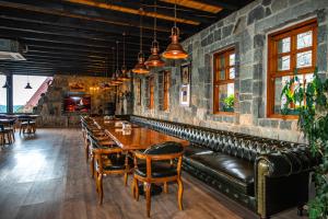a restaurant with a leather couch and tables and chairs at Gafulluk Tatil Köyü in Araklı