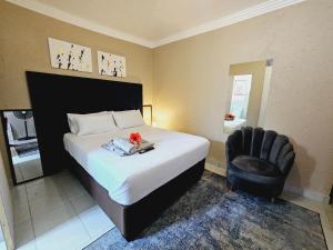 a bedroom with a bed and a black chair at Morokolotsi Guest House in Tzaneen