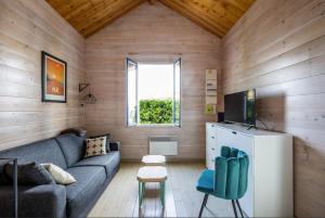 un salon avec un canapé et une fenêtre dans l'établissement La Cabane 18 petit cocon de rêve, à Andernos-les-Bains 4 autres photos