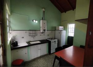 a small kitchen with green walls and white appliances at Deptos Pablos, Apto No 3 in Villa Gesell