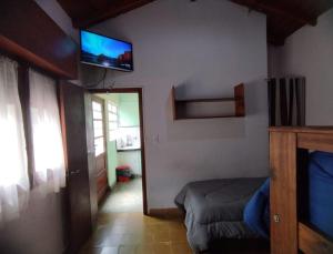 a bedroom with a bed and a television on the wall at Deptos Pablos, Apto No 3 in Villa Gesell