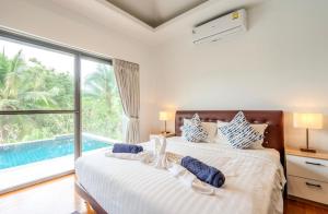 1 Schlafzimmer mit 2 Betten und einem Pool in der Unterkunft 2 Bedroom Very Private and Tranquil Villa Nature SDV004-By Samui Dream Villas in Mae Nam