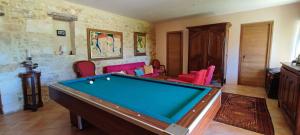 a room with a pool table and red chairs at Domaine de Périer in Cénac-et-Saint-Julien