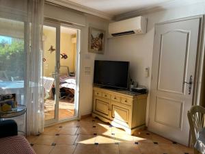 a living room with a television on a dresser at Le Noisetier in Cavalaire-sur-Mer