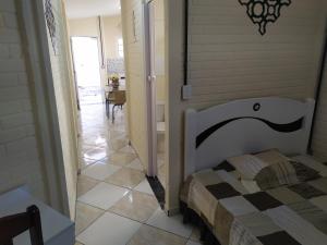 a bedroom with a bed and a hallway with a table at Pousada - Flat - Kitnet - Mobiliada, Confortável e Perto de Tudo in Atibaia