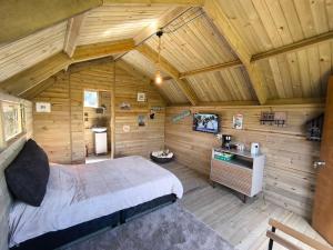 a bedroom in a log cabin with a bed at GlampingTerraza del cielo con jacuzzi in Chocontá