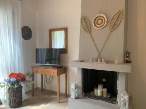 a living room with a fireplace and a television at Christina's Seaside in Lefokastro