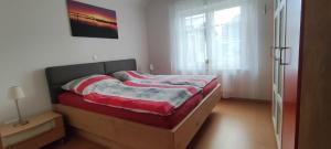 Cette petite chambre comprend un lit avec une couverture rouge et blanche. dans l'établissement Ferienhaus Wangermeer, à Wangerland