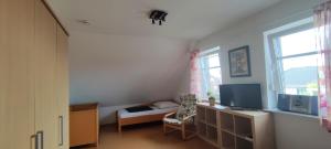 Il comprend un salon doté d'une télévision et d'une fenêtre. dans l'établissement Ferienhaus Wangermeer, à Wangerland