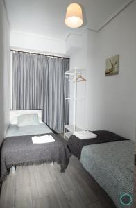 a bedroom with two beds and a window at Home Turia Pio Apartamento de 3 habitaciones in Valencia