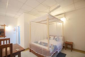 a bedroom with a canopy bed in a room at Happiness Villa and Yala Safari in Tissamaharama