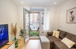 Una sala de estar con un sofá y un televisor. en Garden Gran Via Luxury Aire ac PARKING privado by Apartamentos Logrono, en Logroño