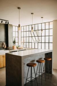 eine Küche mit drei Barhockern an einer Theke in der Unterkunft Stylish Loft with Nature Views, Balcony in the heart of Vejer in Vejer de la Frontera