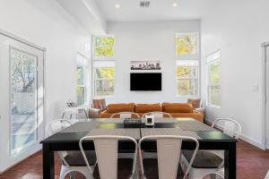Un comedor con una mesa y un sofá. en 3 in 1 Villa Swing Set Game Room Dogs Ok, en Austin