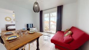 Una sala de estar con un sofá rojo y una mesa. en Etoile des Mers, en Plage-des-Demoiselles 16 fotos más