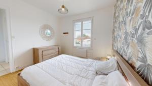 Una habitación blanca con una cama y una ventana en Etoile des Mers, en Plage-des-Demoiselles