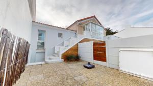 una casa blanca con una valla blanca y un garaje en Etoile des Mers, en Plage-des-Demoiselles