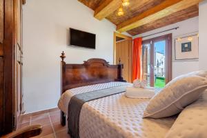 a bedroom with a bed and a tv on the wall at La Quadra Rural Housing in Sant Carles de la Ràpita